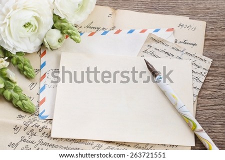 Vintage letters, ink and pen. White persian buttercup flowers (ranunculus) on wooden background, copy space