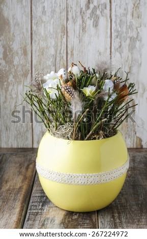 Easter table decoration with twigs, feathers and flowers