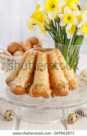 Traditional easter cake and bouquet of daffodils in the background