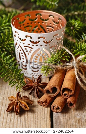 Cinnamon sticks and anise stars on christmas table. Beautiful candle holder in the background.