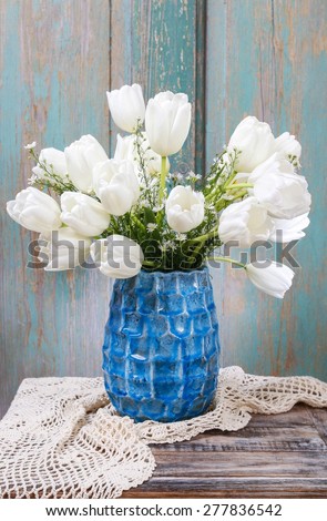 Bouquet of white tulips in blue ceramic vase