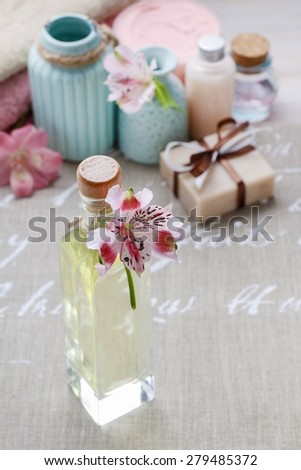Bottle of essential oil and spa cosmetics in the background