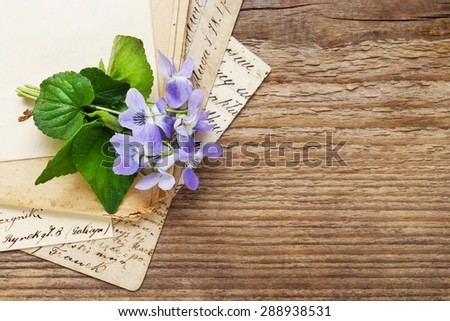 Bouquet of violet flowers (viola odorata) and vintage letters, copy space