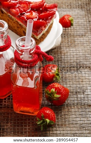 Bottle of strawberry juice, strawberry cake and ripe raw strawberries