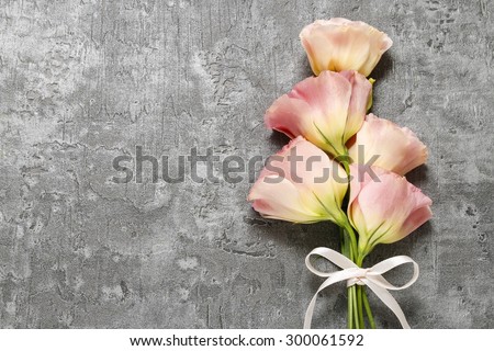 Bouquet of pink eustoma flowers on gray stone background, copy space