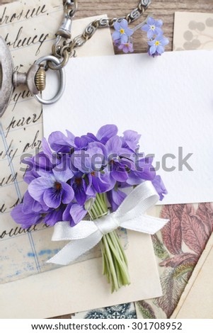 Bouquet of violet flowers (viola odorata) and vintage letters