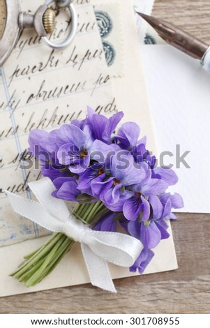 Bouquet of violet flowers (viola odorata) and vintage letters