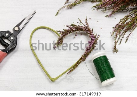 Florist at work: steps of making heather (erica) door wreath in heart shape, step by step, tutorial.