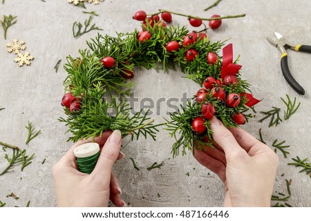 Florist at work: How to make traditional christmas door wreath with thuja twigs and wild rose fruits. Step by step, tutorial.