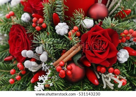 Christmas decoration with red roses, fir, brunia and cinnamon sticks.