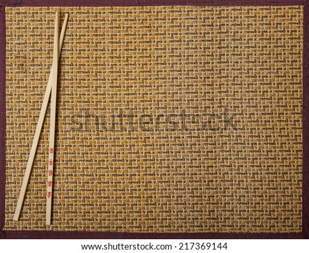 Two chopsticks on sushi mat background for menu