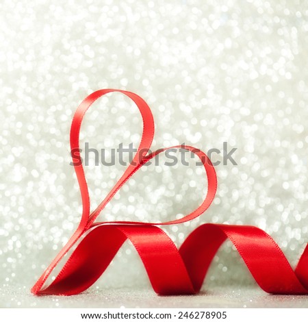 Red hearts of ribbon on silver glitter background,valentines or Mothers day concept.