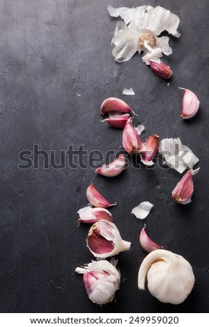 Cloves of garlic aligned in a row over dark  table, above view