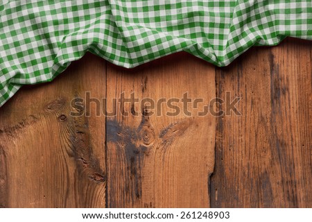old wooden table with picnic tablecloth and copyspace