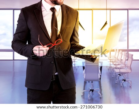 Hipster business man with digital notebook on blurred background office. High resolution.