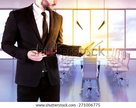 Hipster business man with digital tablet on blurred background office. High resolution.