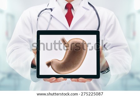 Doctor with stethoscope in a hospital. Stomach on the tablet. High resolution.