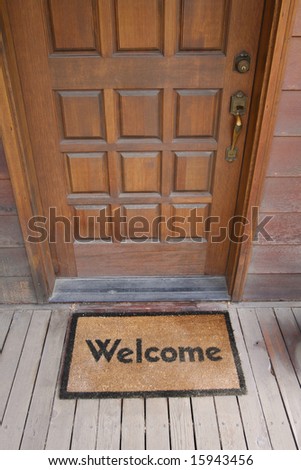 Welcome mat on a wooden deck by front door