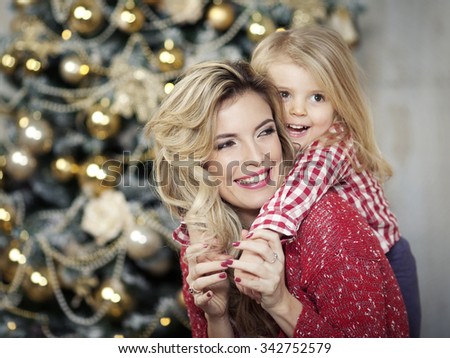 Portrait of beautiful mother and dauther near the Christmas tree