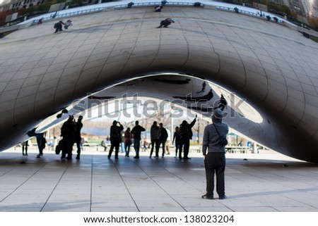 CHICAGO, USA - NOVEMBER 15: Tourists at the Chicago Cloud Gate sculpture on November 15, 2011. The sculpture is also known as \