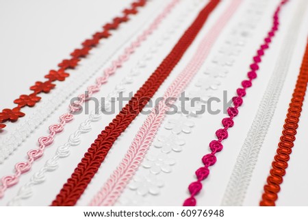 A detail of several red, pink and white ribbons - borders - decoration sewing supplies.
