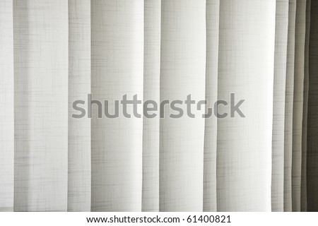 Vertical textile window blinds - jalousie in shades of light brown and grey, stripes background.