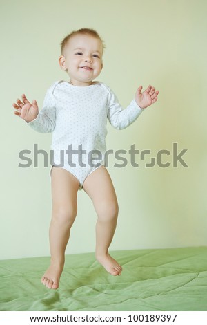 Baby girl jumps at bed