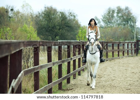 Woman jockey is riding the horse outdoor