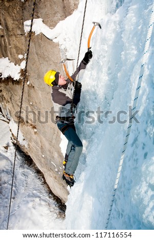 Man climbing frozen waterfall