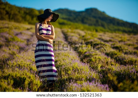 Young woman at lavender field at the sunrise