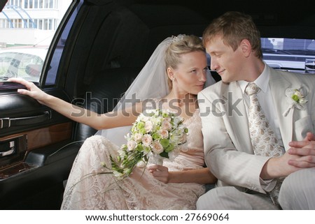 Portrait of the bride  and groom sitting in the car