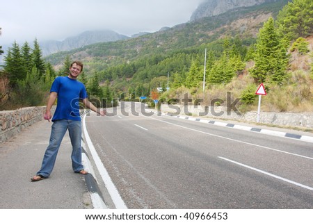 Young man hitchhiking on the road