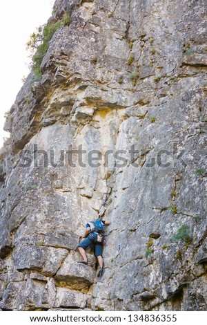 Man practices in climbing at the rock in the Crimea mountains