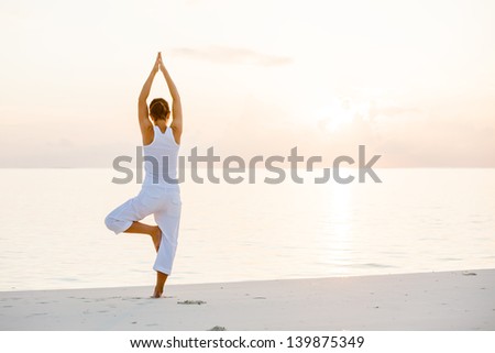Caucasian woman practicing yoga at seashore Caucasian woman practicing yoga at seashore