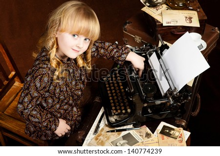 Old-looking image of the small caucasian girl who works at vintage typing machine