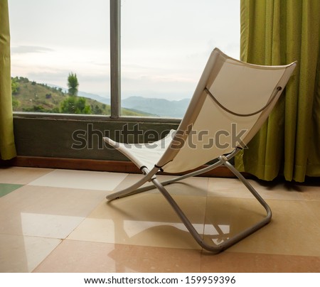 Cozy armchair at the window of mountain hotel in Sri Lanka