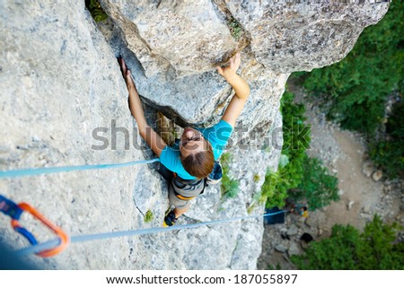 Woman practices in climbing at the rock in the Crimea mountains