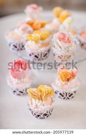 Cupcakes with individual wedding decoration at white table