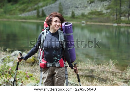 Backpacker posing nearby mountain lake in Altai mountains, Russia
