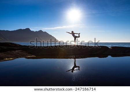 Caucasian woman is doing yoga exercises against picturesque landscapes in Norway