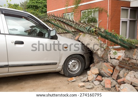 April 25, 2015 Brick fence fallen at the car at the parking during earthquake in Nepal