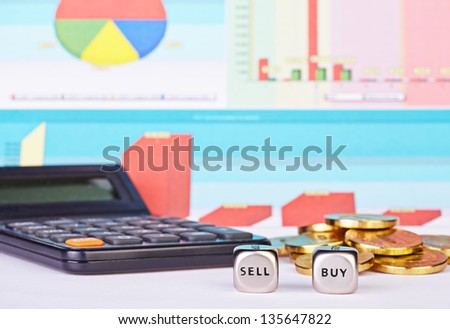 Dices cubes with the words BUY SELL, golden coins, calculator and financial diagrams as background. Selective focus