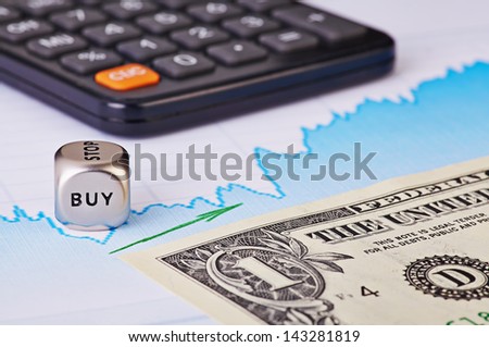 Uptrend financial chart,  one-dollar banknote, green arrow, calculator and dices cube with the word BUY. Selective focus