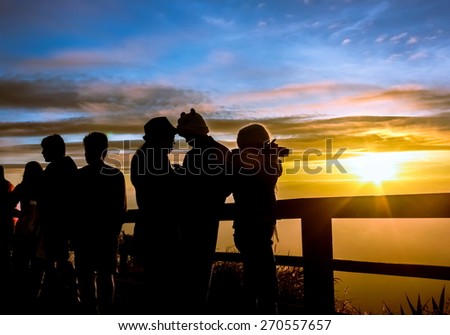 Silhouettes tourists are looking sunrise at view point on phutabberk mountain in north of thailand