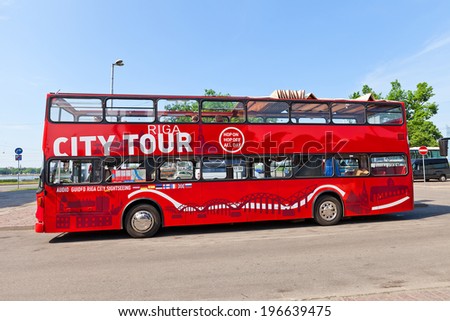 RIGA, LATVIA - MAY 25, 2014: Red double-decker city sightseeing bus waiting for tourists on the Latvian Riflemen square in Riga, Latvia