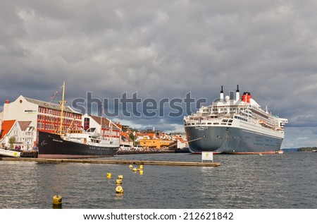 STAVANGER, NORWAY - AUGUST 16, 2014: Cruise ship Queen Mary 2 and museum vessel Rogaland in the port of Stavanger, Norway