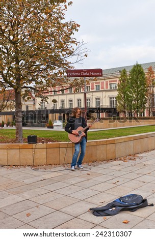 WARSAW, POLAND - OCTOBER 18, 2014: Street musician play guitar on Krakowskie Przedmiescie street (Herbert Hoover Square) in Warsaw, Poland