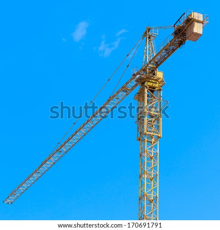 Photo of Industrial construction cranes with clear blue sky