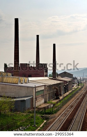Old factory with chimneys and railroad with pink sky