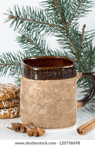 Mug with a hot drink in an environment of sweets and spices